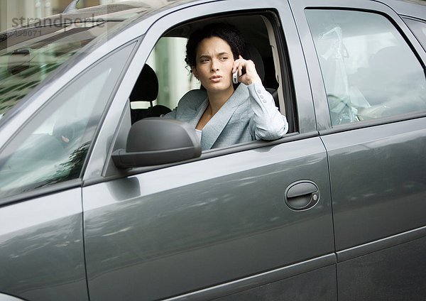 Geschäftsfrau mit Handy im Auto