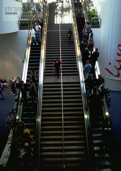 Menschen auf Rolltreppen und Treppen
