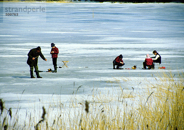 Schweden  Menschen fischen auf gefrorenem Wasser