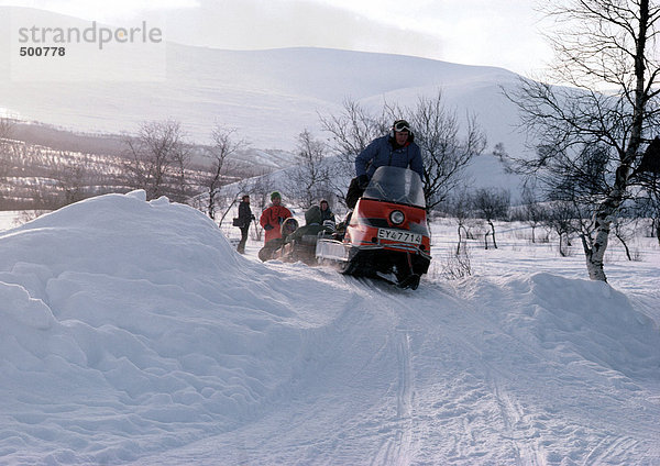 Schweden  Schneemobile auf verschneiter Landschaft