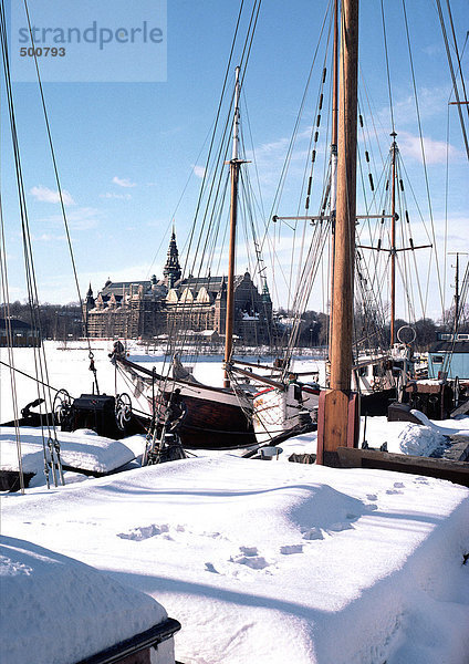 Schweden  Stockholm  Boote im Vordergrund  Kirche in der Ferne  unter Schnee