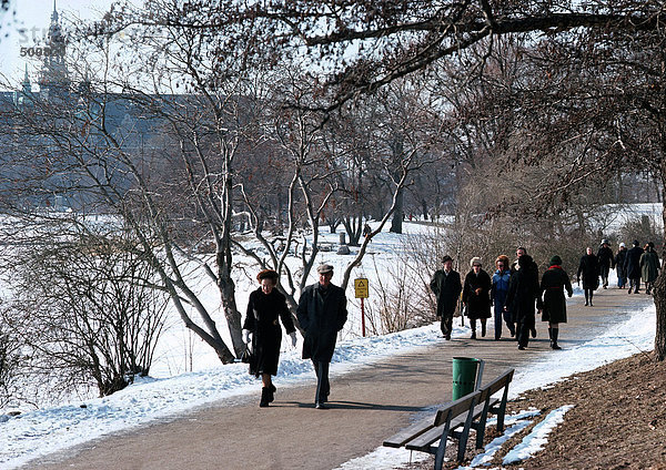 Schweden  Stockholm  Menschen  die im Park im Schnee spazieren gehen