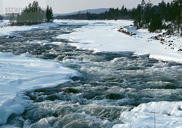 Schweden  Fluss  der durch verschneite Ufer fließt