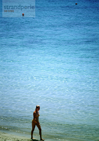 Frau beim Spaziergang am Meer am Strand  Blick in den hohen Winkel