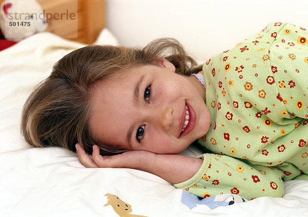 Junges Mädchen lächelnd auf dem Bett liegend  Portrait.