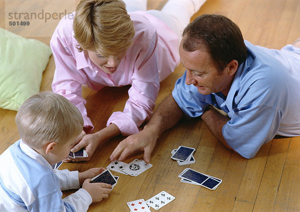 Eltern spielen Karten mit Kind  auf dem Boden  hoher Blickwinkel