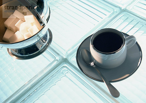Kaffeetasse und Zuckerdose auf Glasbausteinen  Hochwinkelansicht  Nahaufnahme