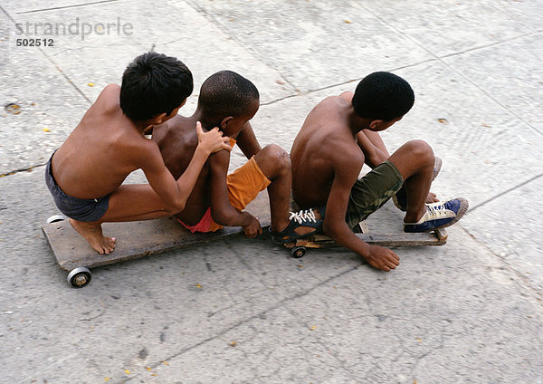 Drei Jungen auf Skateboards sitzend  erhöhte Aussicht