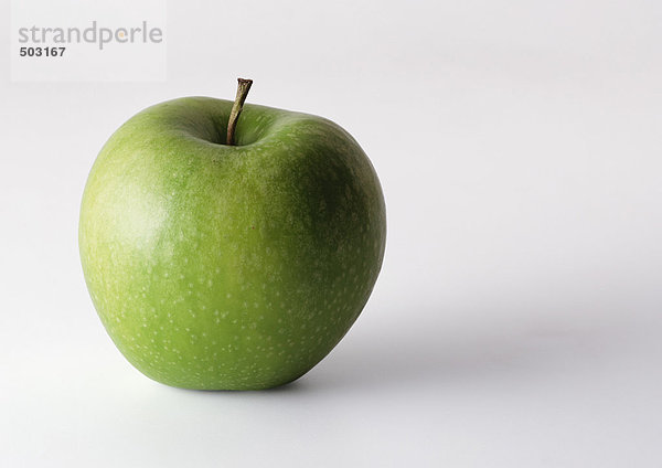 Grüner Apfel mit Stiel  aufrecht stehend  Nahaufnahme  weißer Hintergrund