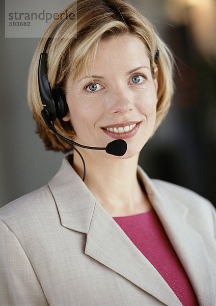 Frau mit Headset  lächelnd vor der Kamera  Portrait