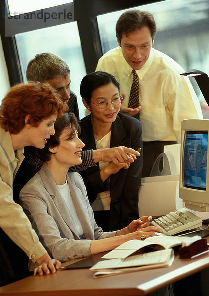 Fünf Geschäftsleute schauen auf den Computerbildschirm
