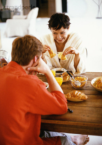 Paar am Tisch sitzend  frühstückend