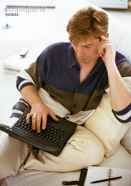 Mann sitzend  mit Laptop-Computer
