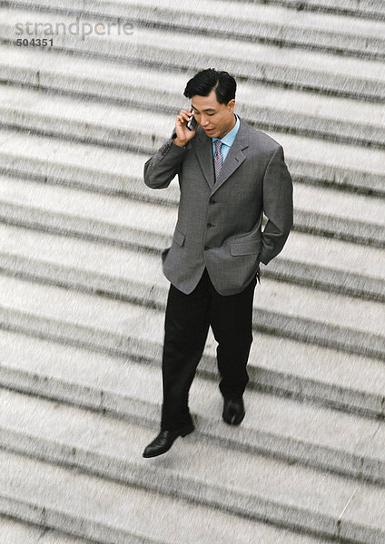 Geschäftsmann mit dem Handy  der die Treppe hinuntergeht  Blick in den hohen Winkel