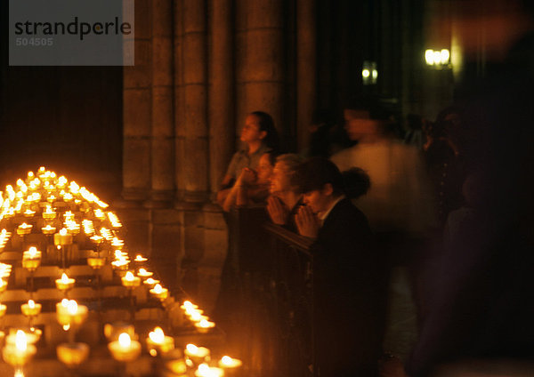 Frankreich  Paris  Kathedrale Notre Dame  Menschen beten neben Kerzen