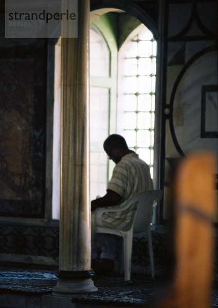 Israel  Jerusalem  Person auf Plastikstuhl in der Moschee  neben Fenster