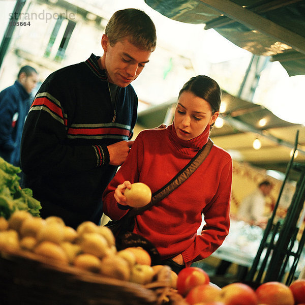 Junges Paar sieht Obst auf dem Freilandmarkt  Obst im Vordergrund verschwommen