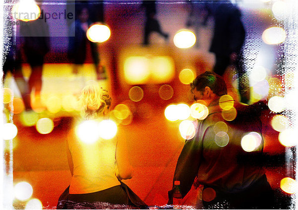 Paar  Rückansicht  mit Personen im Hintergrund  überlagert mit Nachtlicht