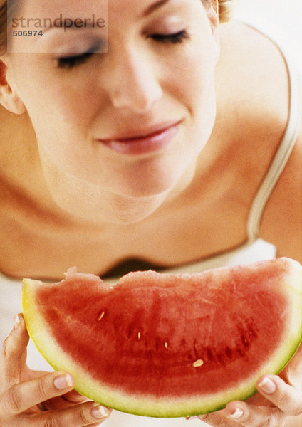 Frau hält Wassermelonenscheibe  Augen geschlossen  Hochwinkelansicht  Nahaufnahme