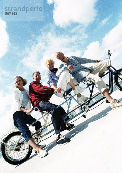 Reife Paare auf Tandemfahrrad am Strand  Portrait