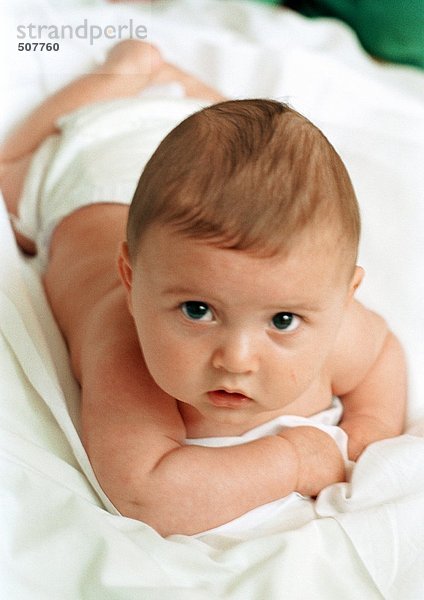 Baby auf dem Bauch liegend mit Blick auf die Kamera  Nahaufnahme