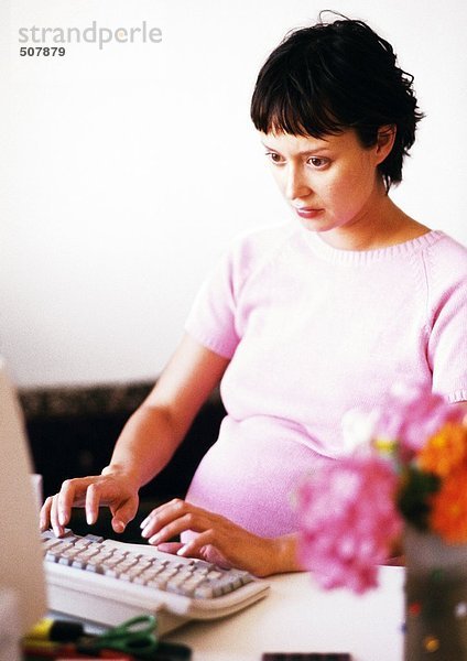 Schwangere Frau bei der Arbeit am Computer