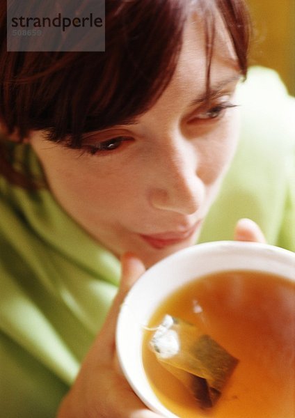 Frau hält Schale mit Tee  Nahaufnahme