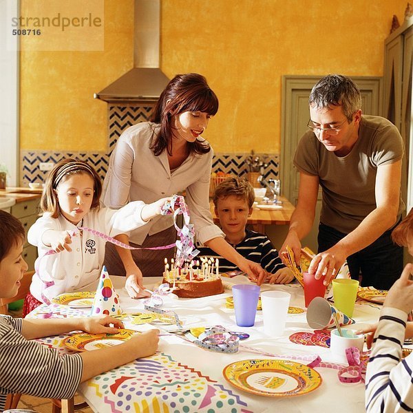 Familie versammelt um Tisch für Geburtstagsfeier