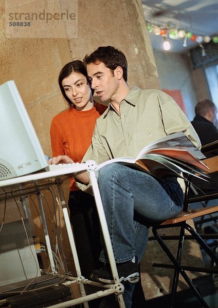 Mann und Frau beim Betrachten des Computers