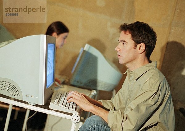 Mann und Frau bei der Arbeit am Computer