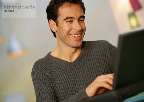 Mann mit Laptop-Computer  lächelnd  Nahaufnahme
