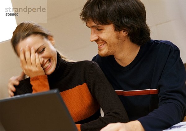 Mann und Frau lächelnd  Frau mit Hand im Gesicht