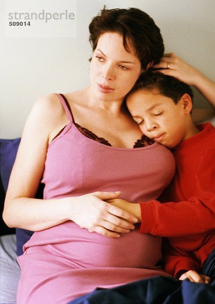 Schwangere Frau sitzend mit Kind