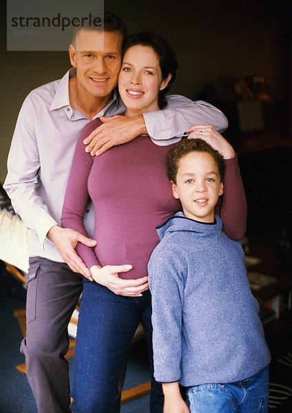 Schwangere Frau und Mann stehend mit Kind  lächelnd  Portrait