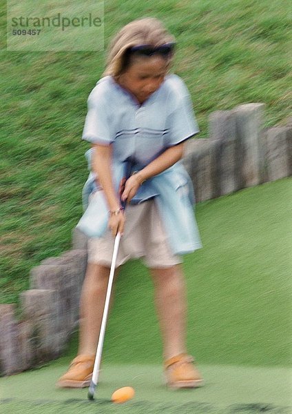 Mädchen spielt Golf  verschwommen