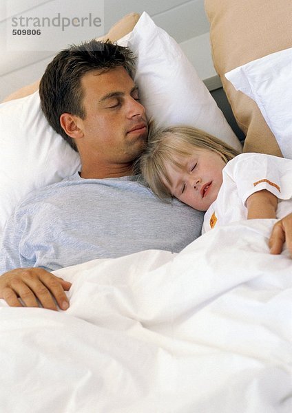 Vater und Tochter schlafen im Bett