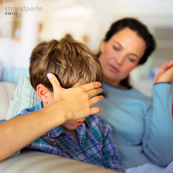 Frau und Kind mit Hand auf dem Kopf