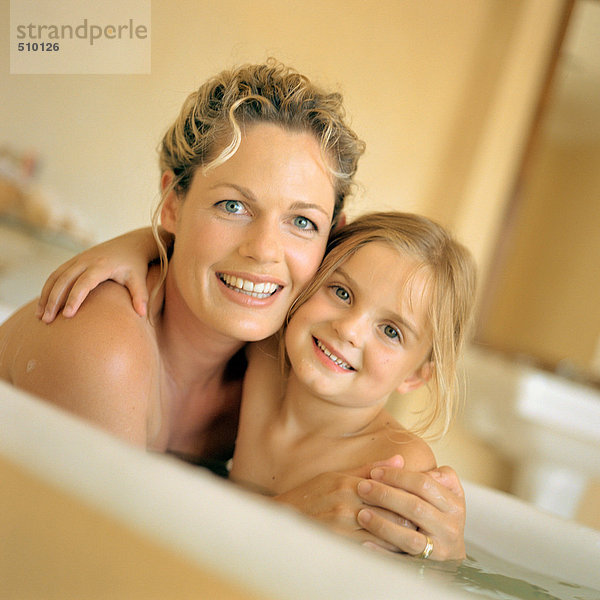 Frau und Mädchen in der Badewanne  lächelnd  Portrait
