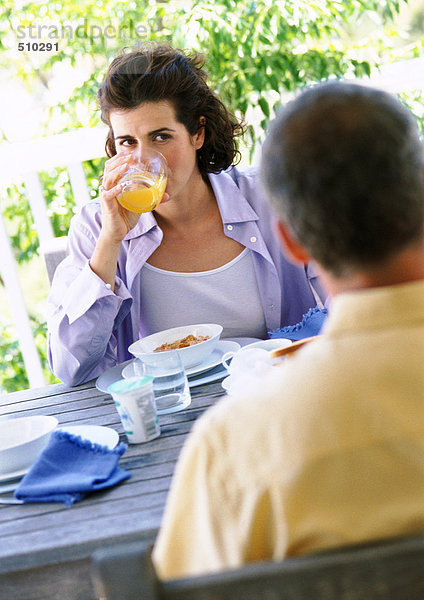 Mann und Frau beim Frühstücken im Freien