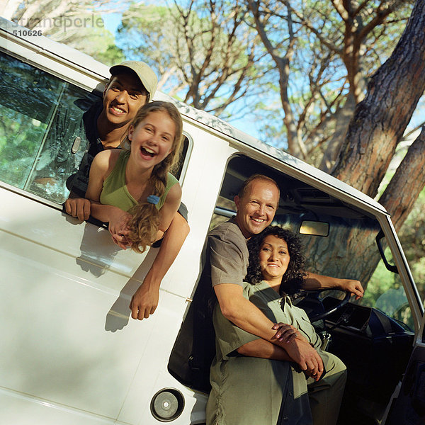 Familienporträt  Kinder kleben Köpfe aus dem Fenster  Eltern in der offenen Tür des Lieferwagens