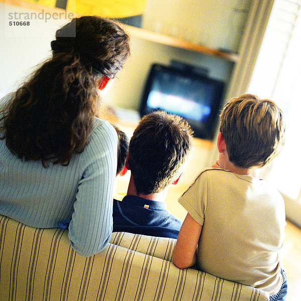 Familie auf dem Sofa sitzend fernsehen  Rückansicht