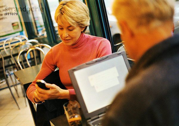 Erwachsenes Paar im Restaurant  Mann mit Laptop  Frau mit Handy.