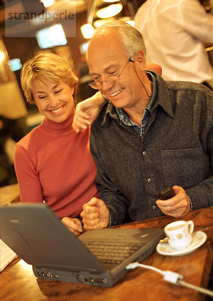 Erwachsenes Paar im Café mit Laptop.