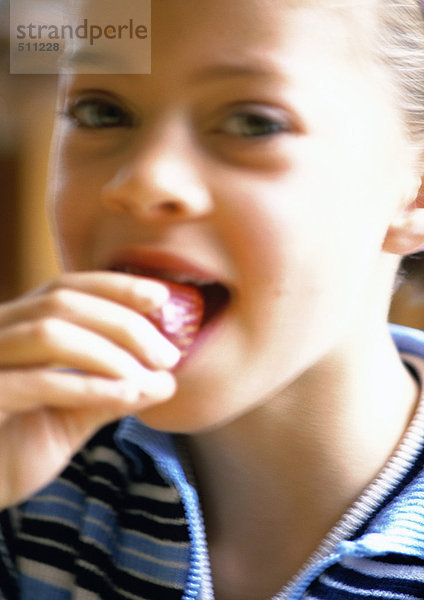 Junges Mädchen isst Erdbeere  Porträt.