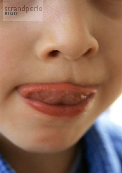 Kind leckt die Lippen  Nahaufnahme des Mundes.