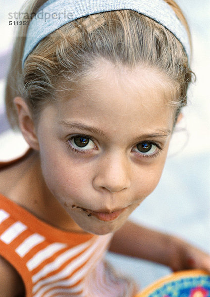 Kleines Mädchen mit Schokolade im Gesicht  Blick in die Kamera  Porträt.