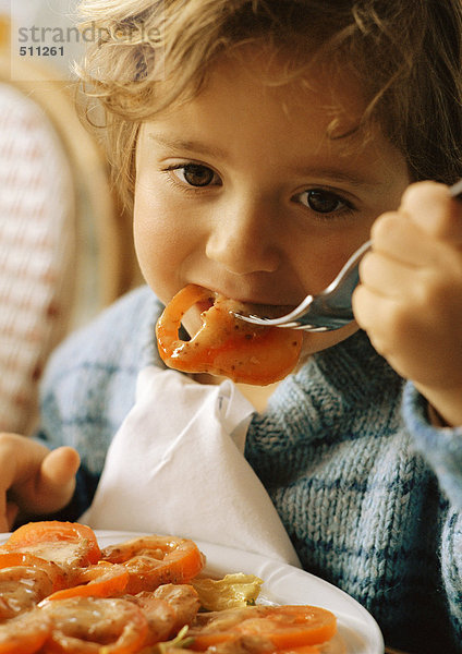 Kind isst Tomatenscheiben  Porträt.