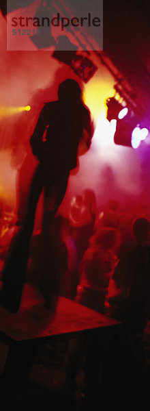 Tänzerin auf Plattform im Nachtclub  Silhouette