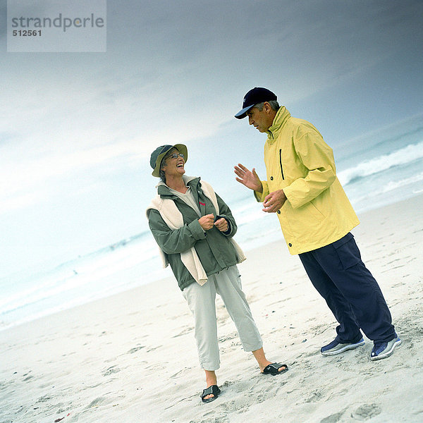 Ein reifes Paar spricht am Strand