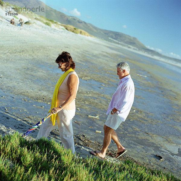 Erwachsenes Paar  das am Strand spazieren geht  Seitenansicht.